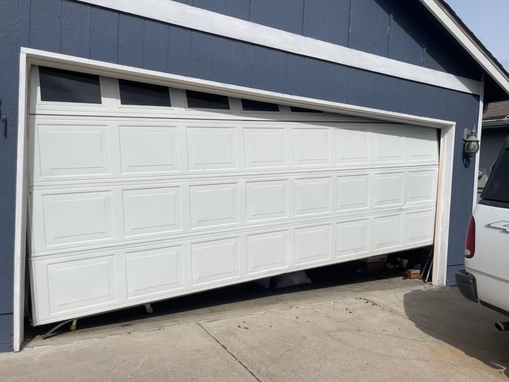 Garage door off track and wedged at an angle before repair in Portland and Salem Metro — Off-Track Repair